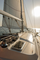 Yacht on ocean. Sailing ship with white sails in the open sea. View from the yacht's deck to mast and sail. Sport, vacation, travel, summer, activity concept