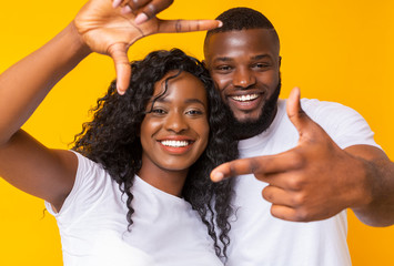 Black man and woman showing frame sign with hands