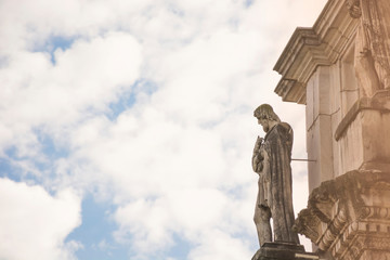 Arch of Constantine statue in Rome closeup on clouds and sky background, Italy. Ancient roman architecture and landmark