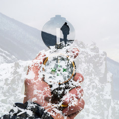 Fototapeta na wymiar Compass in hand on a background of mountains in winter, double exposure