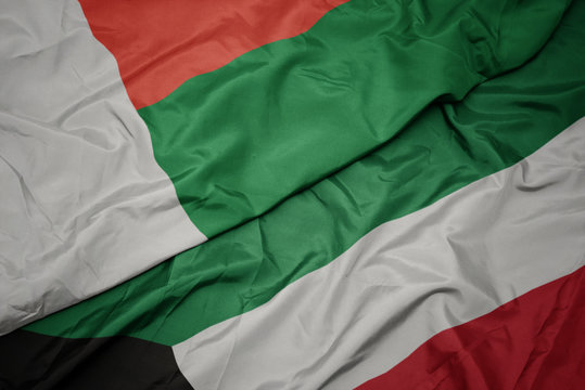 waving colorful flag of kuwait and national flag of madagascar.