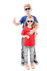 full length view of sister and brother in sunglasses embracing isolated on white