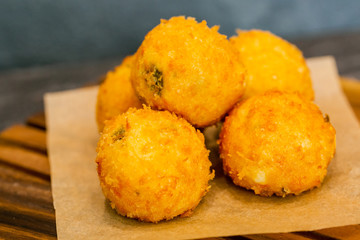 Fried cheese bolls on wooden cutting board