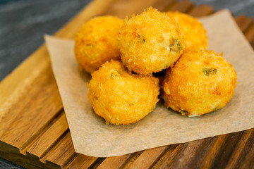Fried cheese bolls on wooden cutting board