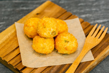 Fried cheese bolls on wooden cutting board