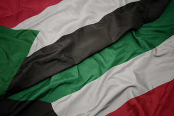 waving colorful flag of kuwait and national flag of sudan.
