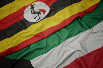 waving colorful flag of kuwait and national flag of uganda.