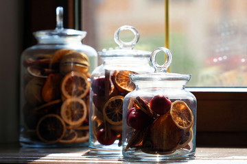 Orange, apples, cinnamon, mulled wine mix in glass jars with a lid, sunlight. Homemade blanks on...