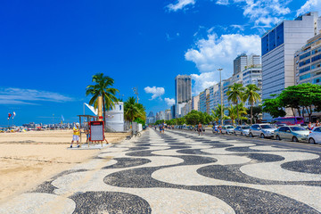 View of Leme beach and Copacabana with palms and mosaic of sidewalk in Rio de Janeiro, Brazil....