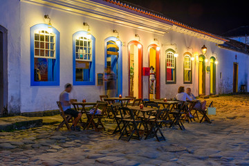 Night view of street of historical center with tables of restaurant in Paraty, Rio de Janeiro,...