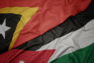 waving colorful flag of jordan and national flag of east timor.