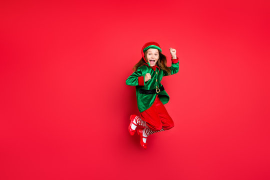 Full length body size view of nice attractive cheerful cheery funny funky overjoyed small little pre-teen elf having fun rejoicing isolated over bright vivid shine red background