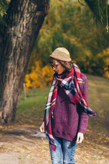 Fototapeta na wymiar A beautiful happy smiling young woman in knitted hat in the autumn park