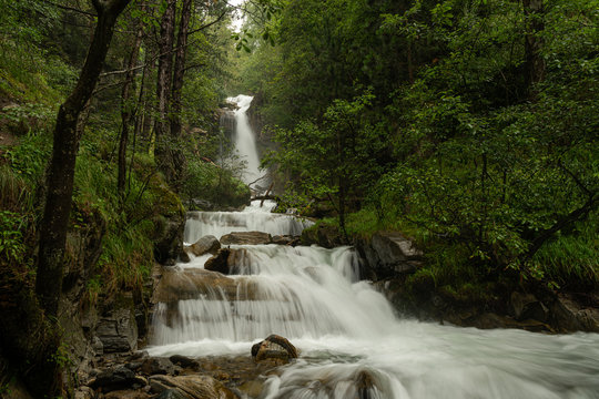 Waterfall in the forest near Schlanders on a cloudy day in summer