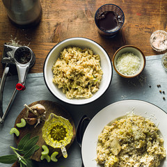 Classic Italian risotto with mushrooms on a wooden table with a blue linen tablecloth. red wine. bottle and glasses. top shots