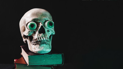 Scary skull on pile of tomes