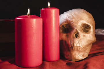Red candles and skull in plastic bag