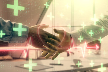 Multi exposure of heart icon hologram on office background with two men handshake. Concept of medical education