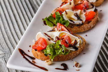 Bruschetta with tomatoes, lettuce, camambert, balsamic vinegar