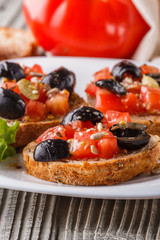 Italian bruschetta with tomato, black olives, lettuce and mustard