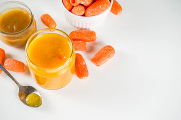 Homemade carrot jam with fresh baby carrots, copy space