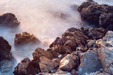 Beautiful stones, rocks and sea in a mystical haze at sunset. Long exposure. cool light landscape. Turkey. Aegean sea shore.