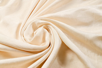 Soft smooth beige silk fabric background. Fabric texture.