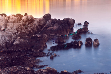 Sharp stones and rocks in the turquoise, blue sea. Beautiful seascape. Aegean coast in Turkey at sunrise. Bodrum.