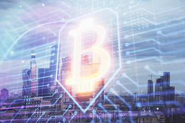 Double exposure of bitcoin sign drawing hologram on cityscape background. Concept of crypto economy