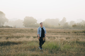 girl cuts ears of corn in a meadow in the morning at dawn in the fog