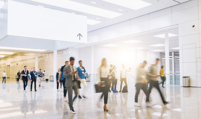 trade fair visitors walking in a clean futuristic corridor with banner for copy space