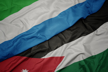 waving colorful flag of jordan and national flag of sierra leone.