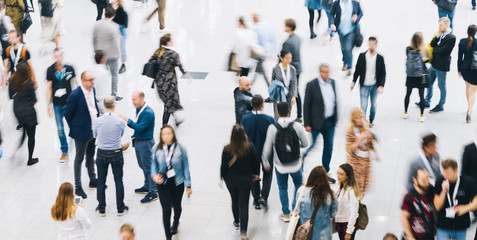 Anonyme Menge Leute geht durch Halle einer Messe