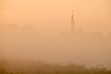 Fog covered village view at sunrise
