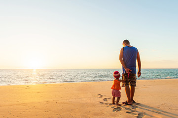 Excited little girl and her father on the beach.