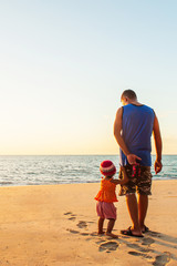 Excited little girl and her father on the beach.