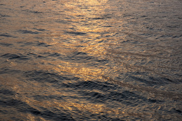 Waves on river surface in sunset light