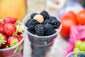 Fresh berries in plastic glasses for sale in market