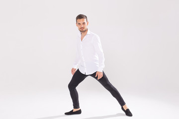 Fototapeta na wymiar Handsome young man dancing on white background with copy space