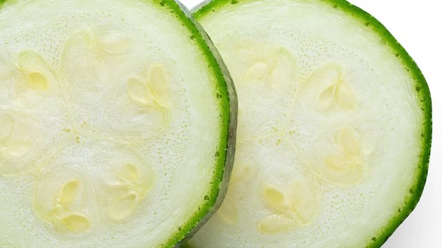 panning slice of zucchini isolated on white background. top view