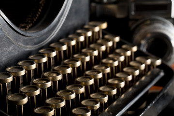 Vintage retro typewriter keys close up and analog film camera on brown wood table background - journalism or writer concept, selective focus