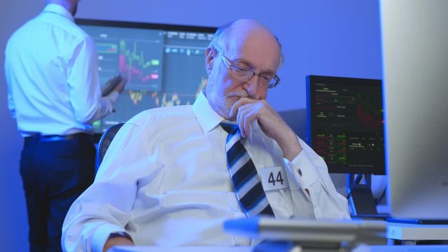 Pensive trader thinking at workplace