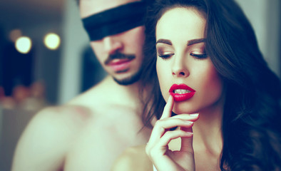 Sensual woman foreplay with young man in blindfold - obrazy, fototapety, plakaty
