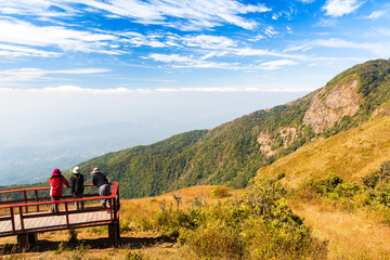 A group of tourists relaxing on the mountain peak.