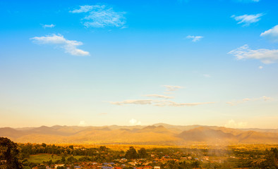 Village in the mountain valley in the sunset time with blue sky