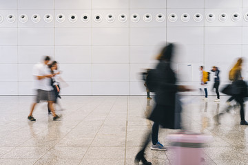     Viele anonyme Leute gehen durch Gang einer Messe 