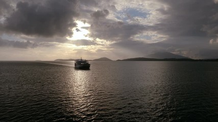 Silhouette of a cruise ship sailing the Mediterranean sea against the background of picturesque mountains at dusk. 4K
