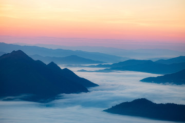 Dramatic sunset and sunrise over mountain sea of fog morning twilight evening sky.