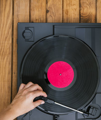 Top view person placing vinyl record in player