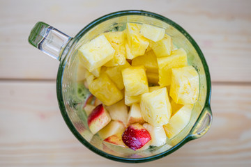 Mixed Spinach with Peach and Pineapple in a Blender, Smoothie Preparation Process, Top View, Free Space for Text